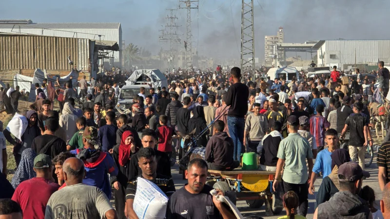 FILE PHOTO: Palestinians gather at an aid distribution center in Deir Al-Balah, in the Gaza Strip