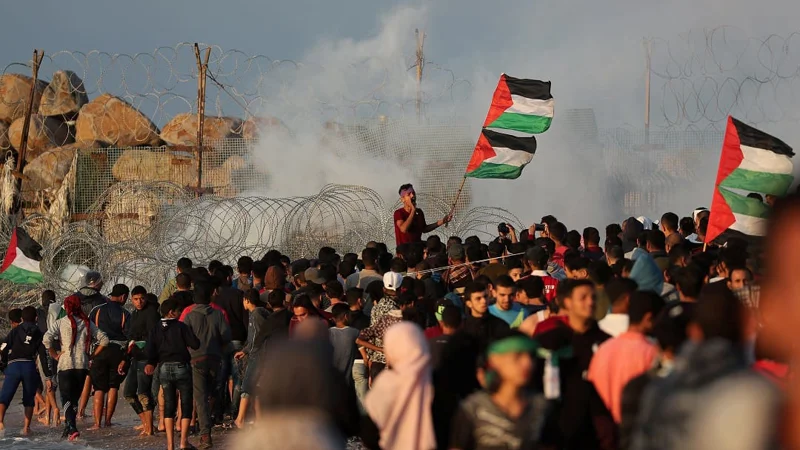 Demonstrator holding Palestinian flags shouts during a protest calling for lifting the Israeli blockade on Gaza, at the beachfront border with Israel, in the northern Gaza Strip